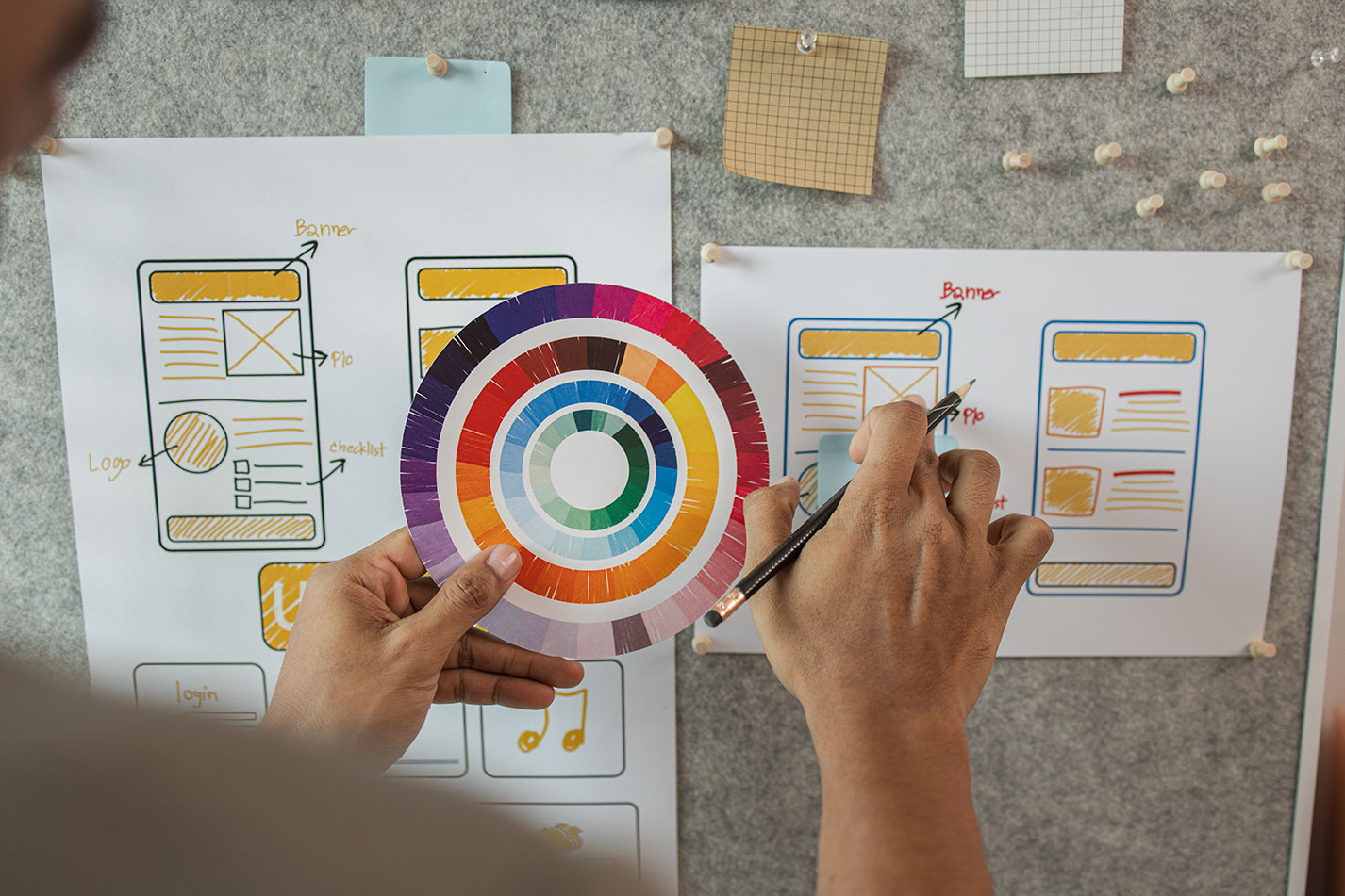 Person out of focus looking at colors and website wireframes